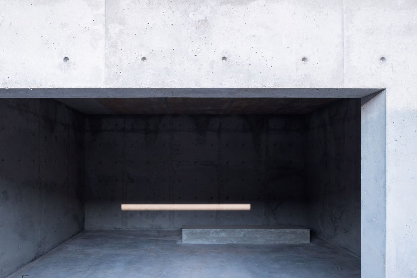 McNeal 020 Pavilion by Atelier David Telerman — A monolithic concrete pavilion interior captured from the threshold, revealing nested rectangular frames receding into shadow.