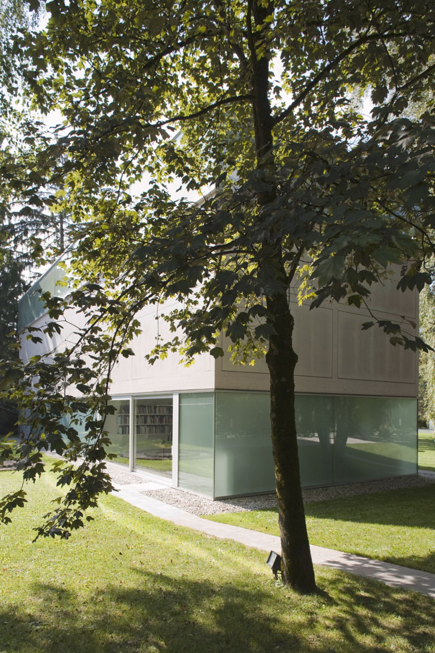 Sammlung Goetz by Herzog & de Meuron — The Sammlung Goetz gallery emerges from verdant grounds where a mature birch tree frames the composition in asymmetric counterpoint to the building's rigid...