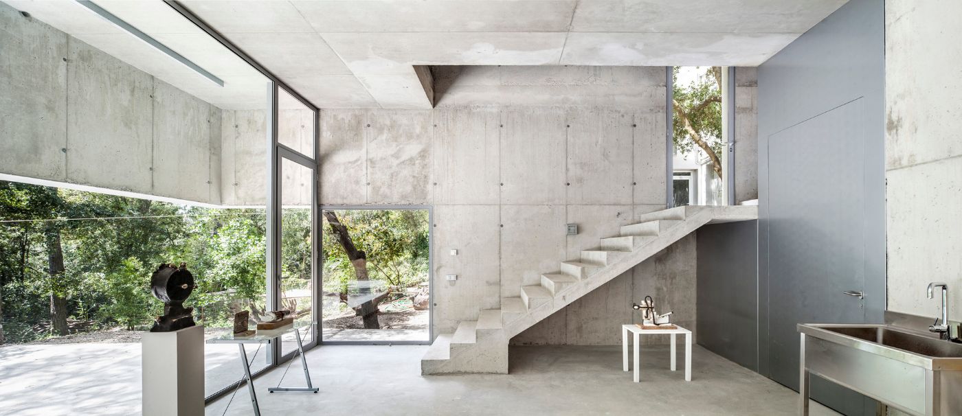 Arranz Bravo Studio by Garcés - De Seta - Bonet Arquitectes — A monolithic concrete interior anchored by a cantilever stair rising toward a clerestory.