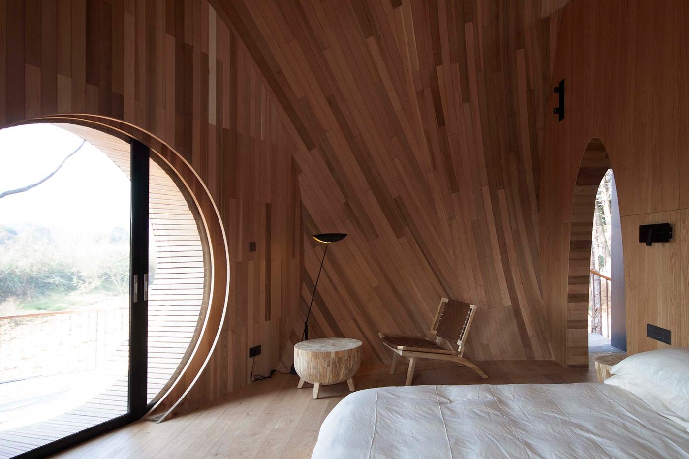 The Seeds Houses by ZJJZ Atelier — Interior of a Seeds House reveals the wooden envelope's spatial logic through longitudinal timber planking that slopes dramatically overhead.