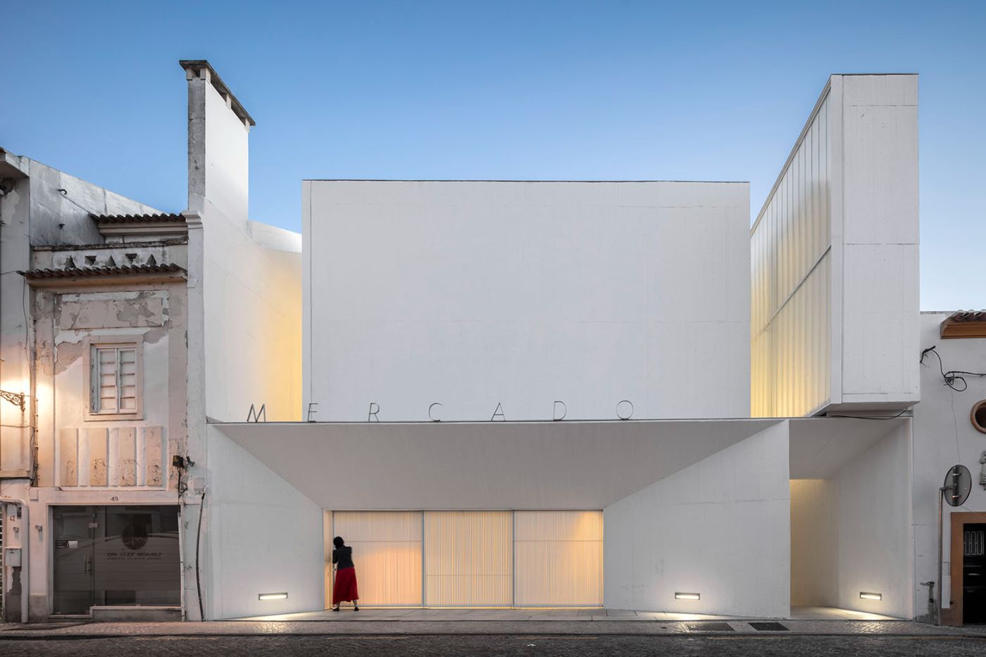 Abrantes Municipal Market by ARX Portugal — The Abrantes Municipal Market presents a minimalist white facade organized around a central void.