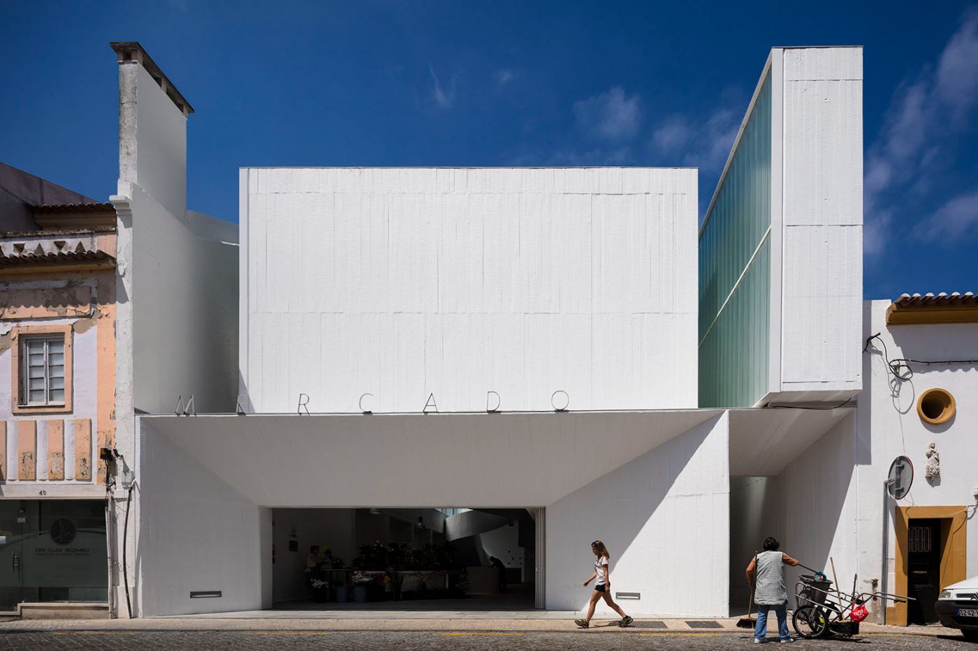 Abrantes Municipal Market by ARX Portugal — The Abrantes Municipal Market presents a bold white rendered facade facing the street, with the word 'MERCADO' spelled across the upper facade in capital...