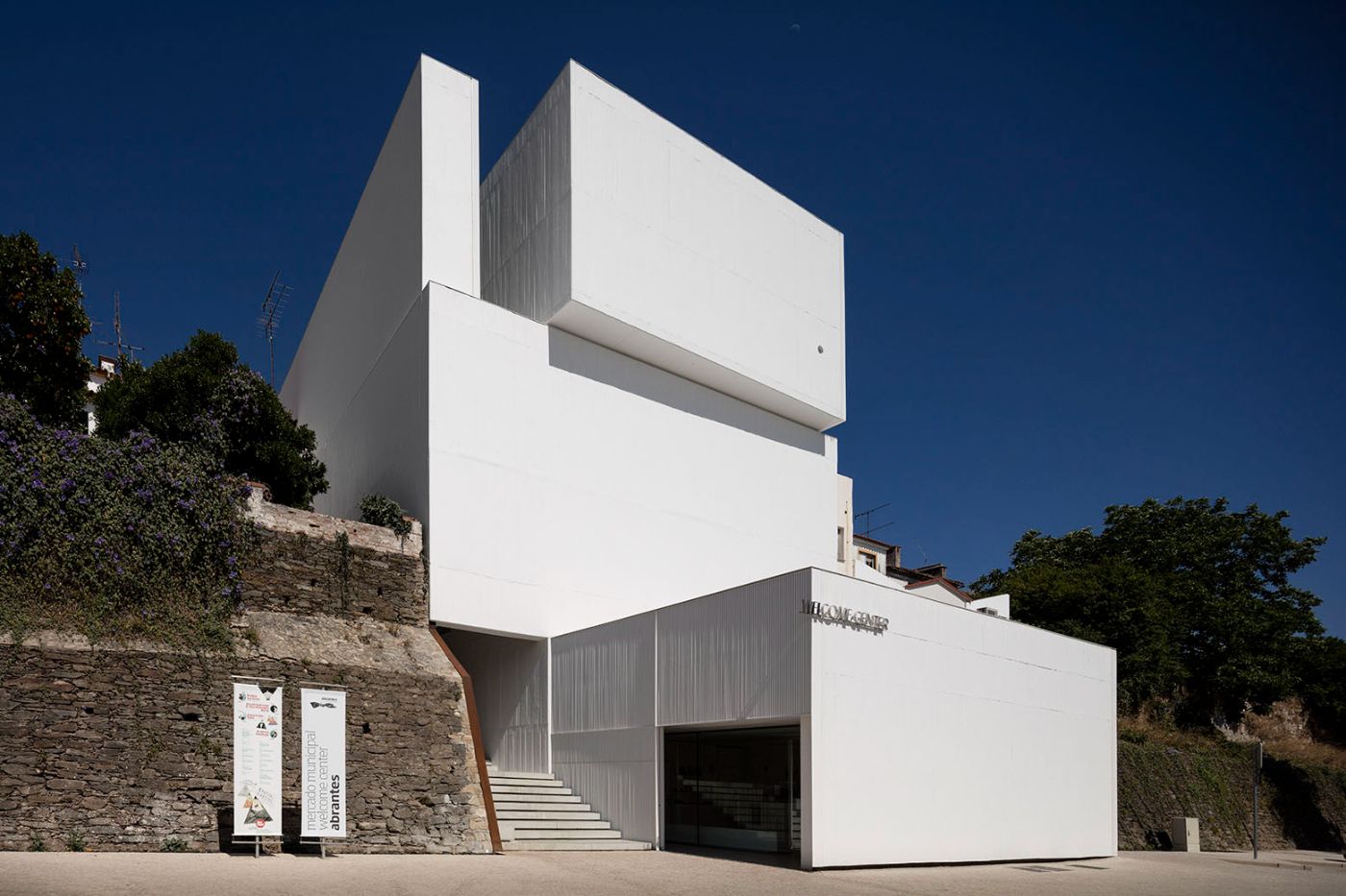 Abrantes Municipal Market by ARX Portugal — ARX Portugal's municipal market in Abrantes presents a stark white geometric composition stacked vertically against a hillside context.