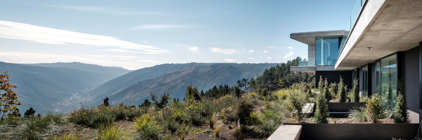 Casa de São Lourenço by P-06 Atelier and Site Specific by P-06, Site Specific, Rogério de Azevedo — The modernist hotel volume cantilevers across mountainous terrain at 1,250 meters elevation, its austere geometry fractured by deep-blue-tinted glazing...
