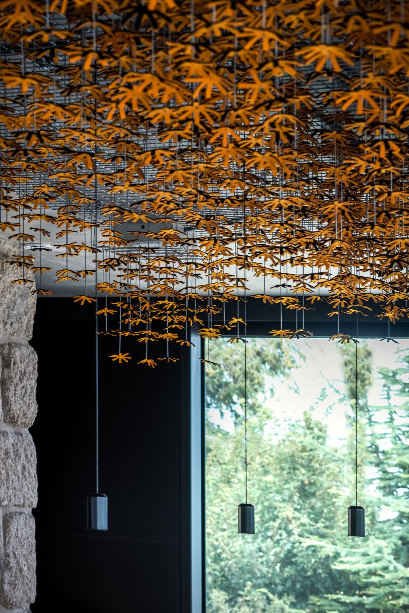 Casa de São Lourenço by P-06 Atelier and Site Specific by P-06, Site Specific, Rogério de Azevedo — Suspended golden larch foliage hangs from a structural grid above a glazed threshold, creating a botanical overhang that frames the view to the Serra da...