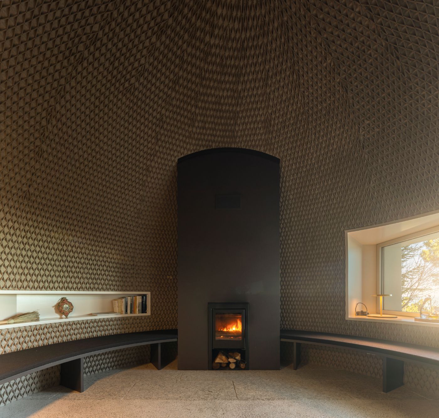 Casa de São Lourenço by P-06 Atelier and Site Specific by P-06, Site Specific, Rogério de Azevedo — A cylindrical black stove forms the focal point of a symmetrically composed interior, its darkened exterior contrasting sharply against textured cream...