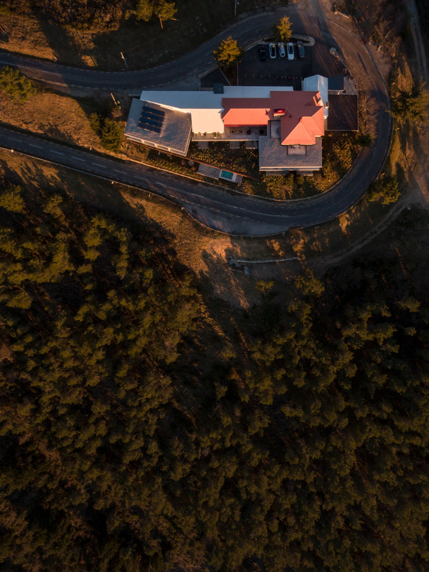 Casa de São Lourenço by P-06 Atelier and Site Specific by P-06, Site Specific, Rogério de Azevedo — Aerial view of Casa de São Lourenço revealing the hotel's geometric footprint nestled within dense coniferous forest at 1,250 meters elevation.