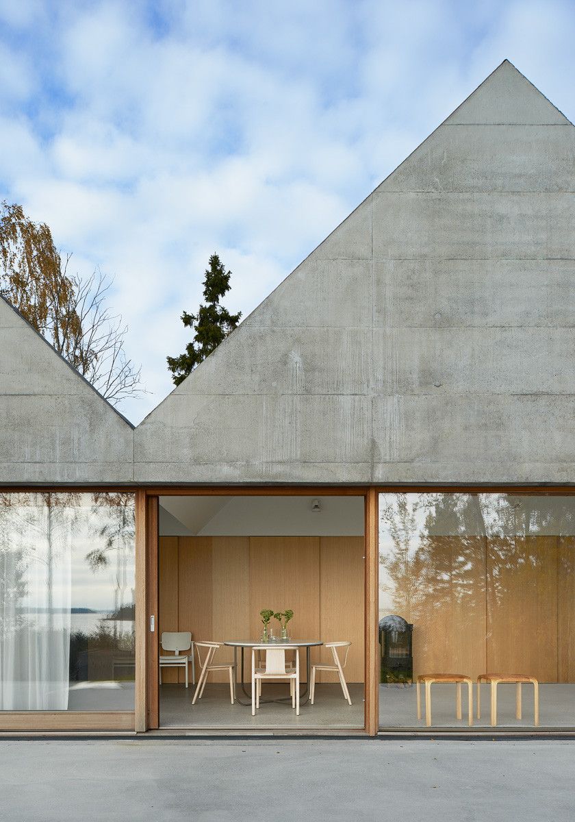 Summerhouse Lagnö by Tham & Videgård Arkitekter — The gabled facade of Summerhouse Lagnö presents a monolithic concrete volume with horizontal board-mark striations running across its surface.