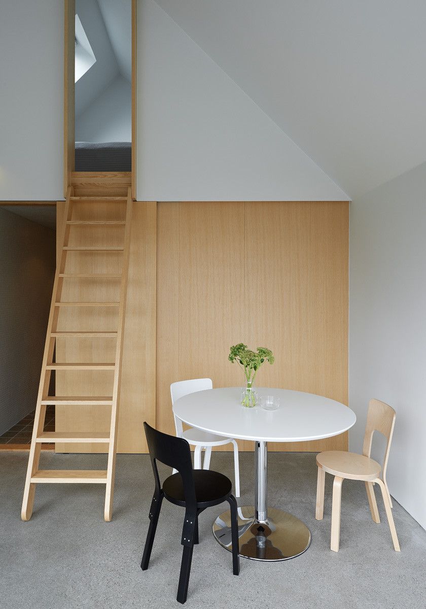 Summerhouse Lagnö by Tham & Videgård Arkitekter — Interior view of the summerhouse's dining area, framed through continuous glazing with timber mullions.