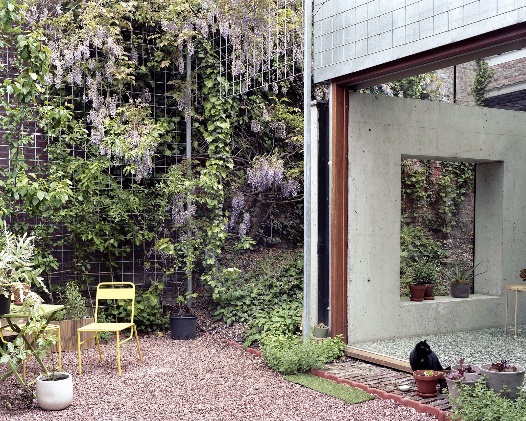 ‘Room in the City’ by 51N4E — A courtyard threshold framed by layered concrete and vegetation.