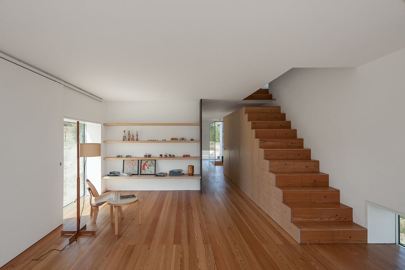 Fonte Boa House by João Mendes Ribeiro — Interior view of Fonte Boa House showcasing the open-plan living space with continuous timber flooring in warm honey tones.