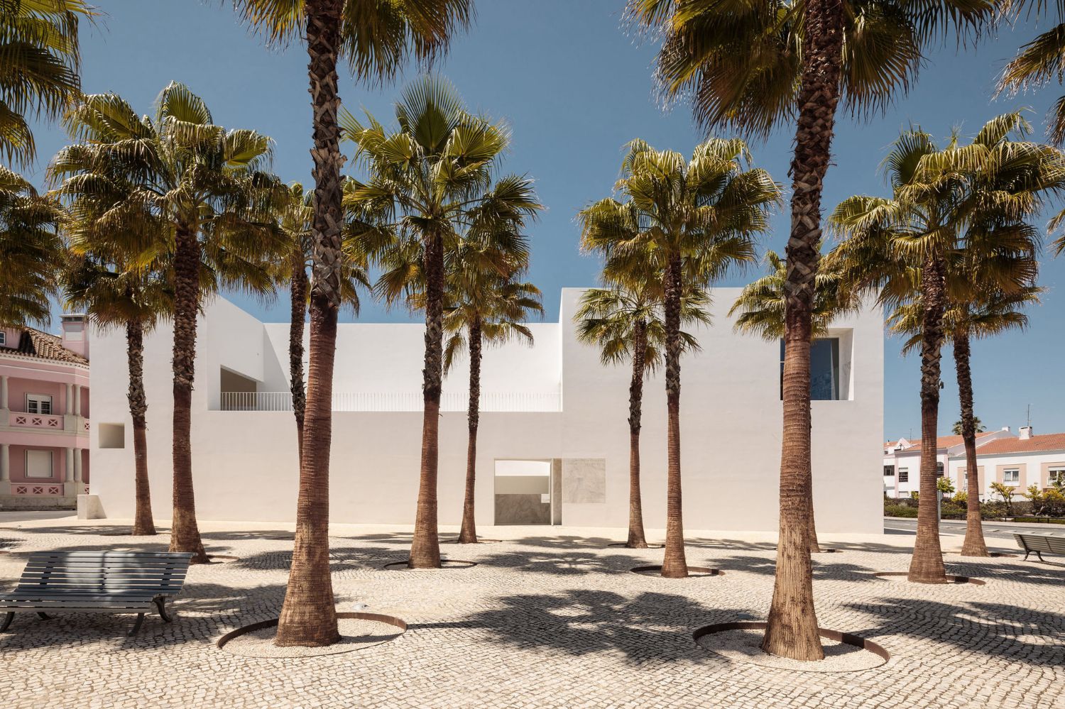 Grândola’s Library and Municipal Archive by Matos Gameiro Arquitectos + Pedro Domingos Arquitectos — The library and archive building presents itself as a monolithic white rendered volume anchoring Grândola's central square.