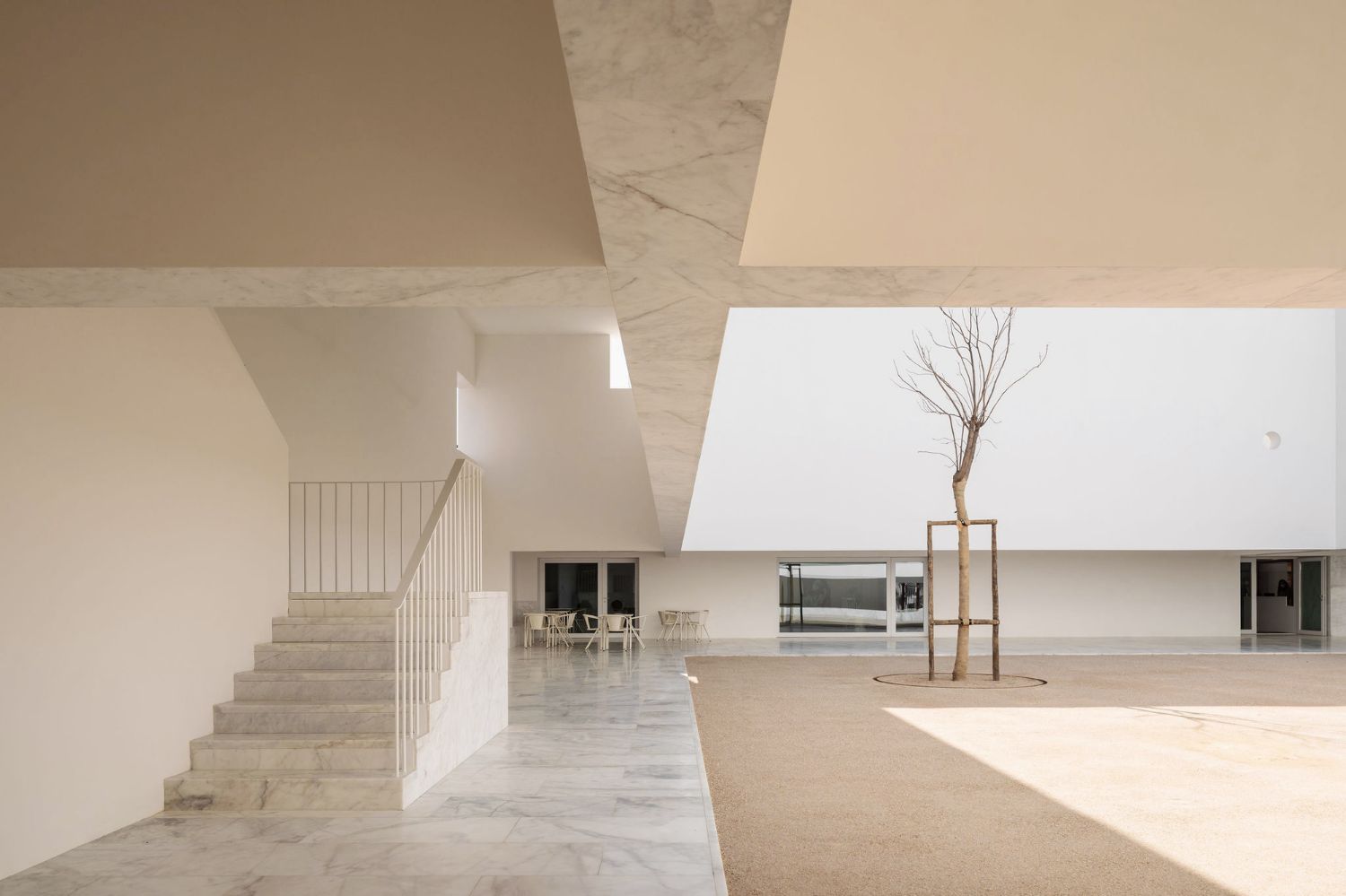 Grândola’s Library and Municipal Archive by Matos Gameiro Arquitectos + Pedro Domingos Arquitectos — A rendered white interior courtyard with geometric skylights overhead casting sharp shadows across the floor.