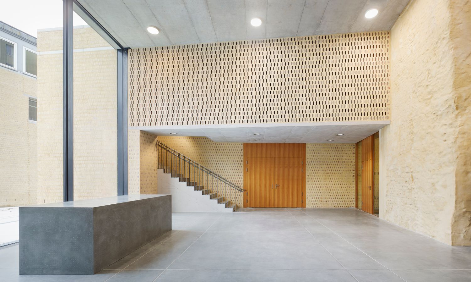 Philosophical Seminar at the Cathedral Square by Peter Böhm Architekten — The atrium of the Philosophikum presents a double-height reception space defined by material contrast and geometric clarity.