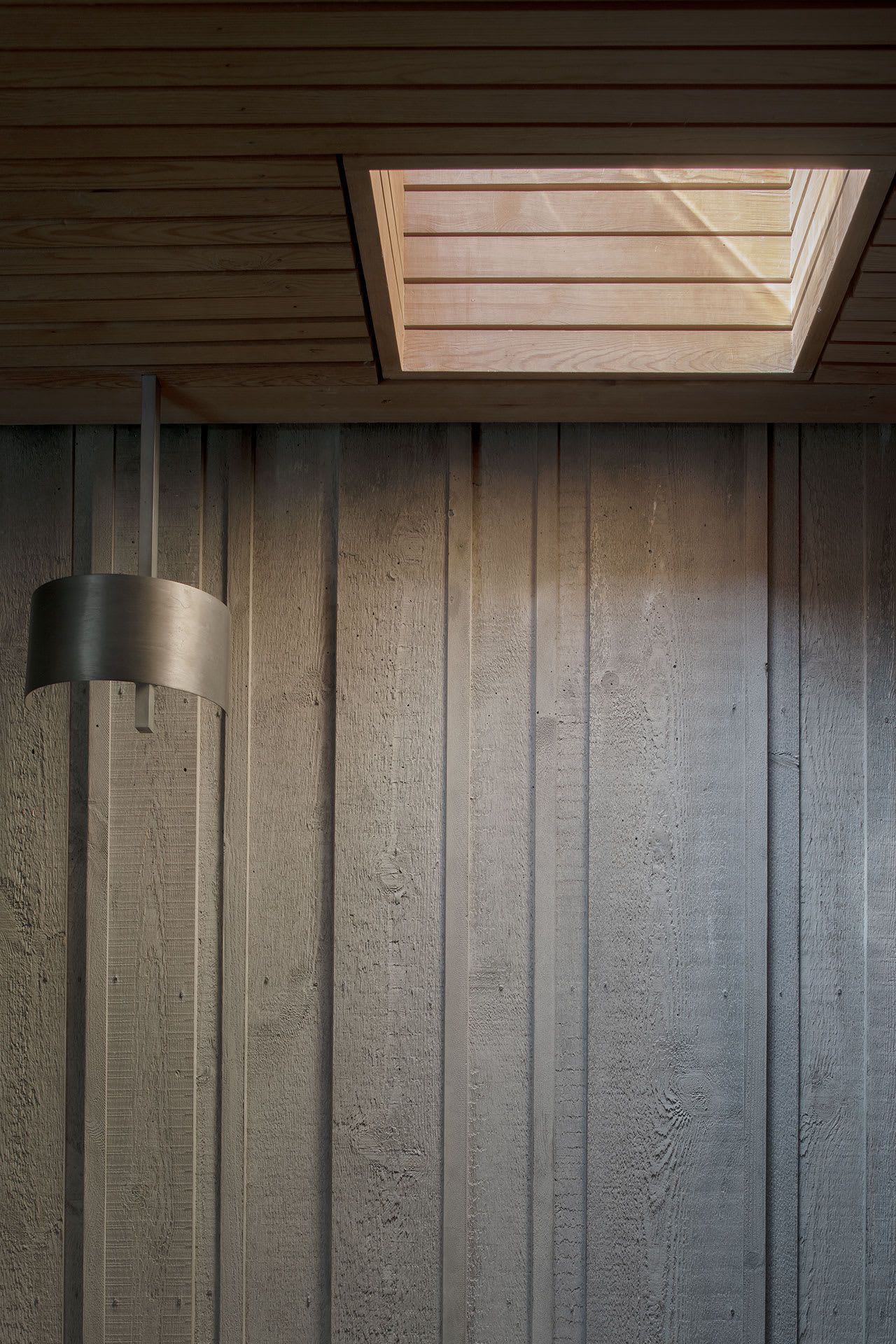 Gävle Crematorium by ELLT captured by Andy Liffner — Interior detail of Gävle Crematorium showing the junction between board-formed concrete wall and timber-lined soffit.