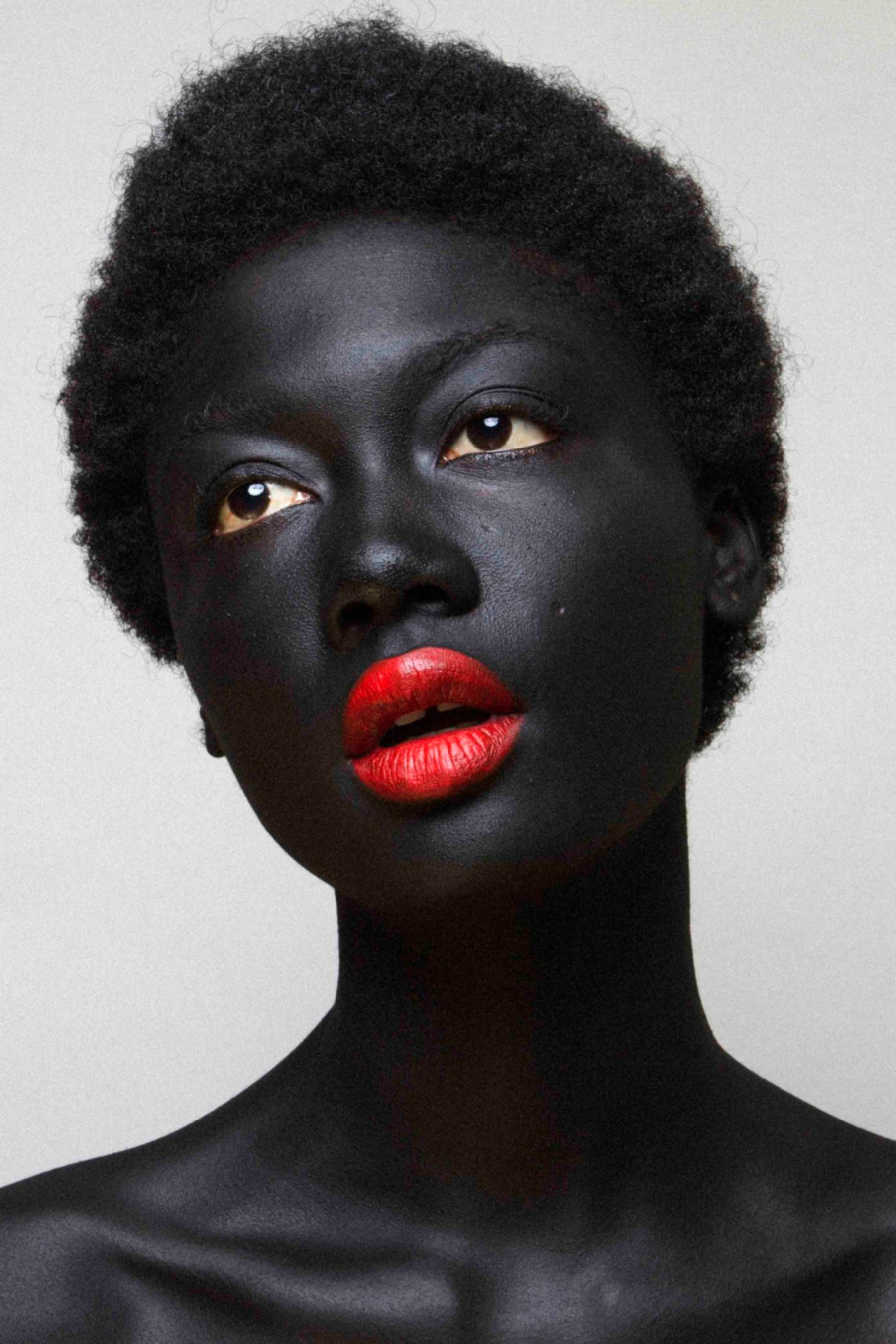 Selected works by Lakin Ogunbanwo — Portrait photograph featuring a figure with deep-toned skin against a neutral cream background.