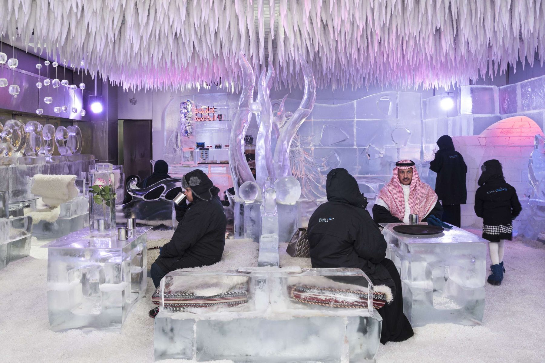 Garden of Delight by Nick Hannes — An ice hotel interior rendered entirely in translucent and opaque ice blocks, illuminated by purple and pink neon lighting from above.