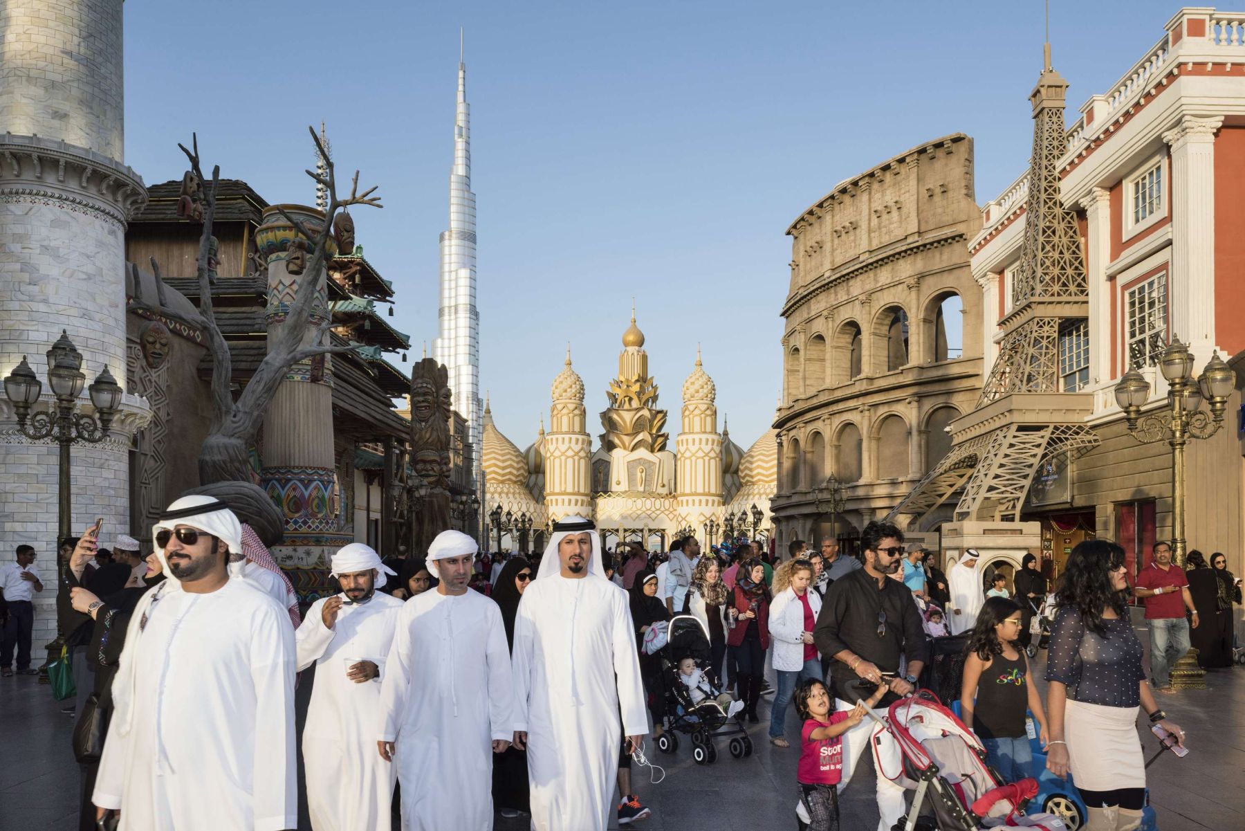 Garden of Delight by Nick Hannes — A crowded pedestrian plaza in Dubai's Old Town district centers on the ornate Mosque of Mohammed Al-Faridi, its golden domes and white minaret rising...