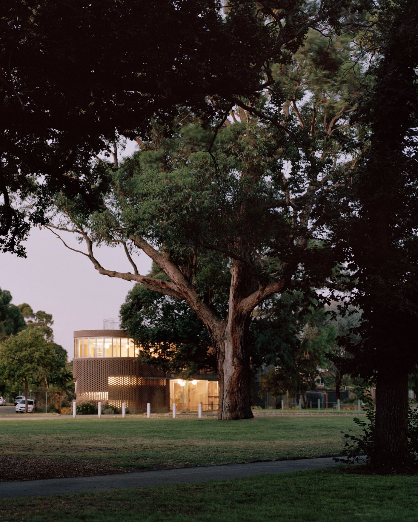 Rose House by Baracco+Wright Architects — Rose House presents itself across the lawn as a cylindrical brick volume crowned by a colonnade of vertical columns.