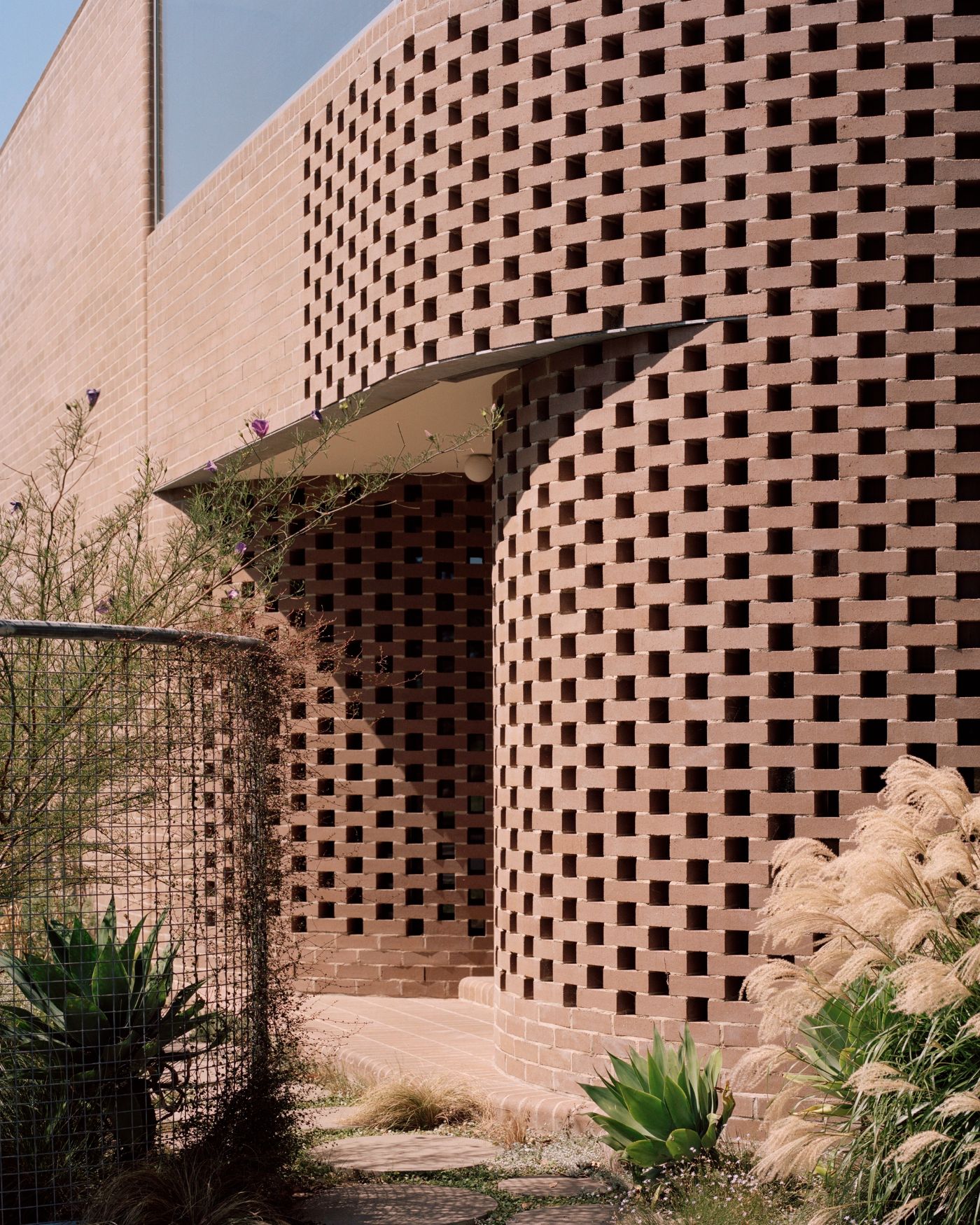 Rose House by Baracco+Wright Architects — The cylindrical brick tower of Rose House presents a perforated facade of stacked rectangular voids arranged in regular horizontal bands across the...