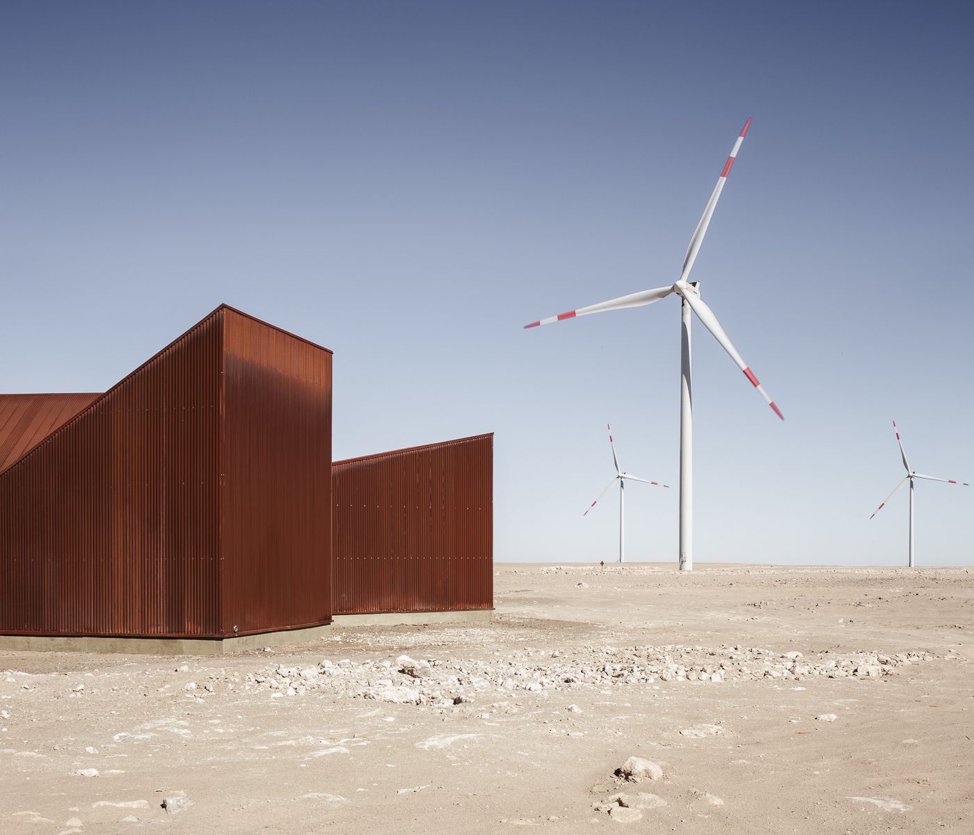 Center of Interpretation of the Desert by Emilio Marín and Juan Carlos López — Three trapezoidal volumes clad in corrugated corten steel occupy the pale desert floor of Chile's Atacama region.