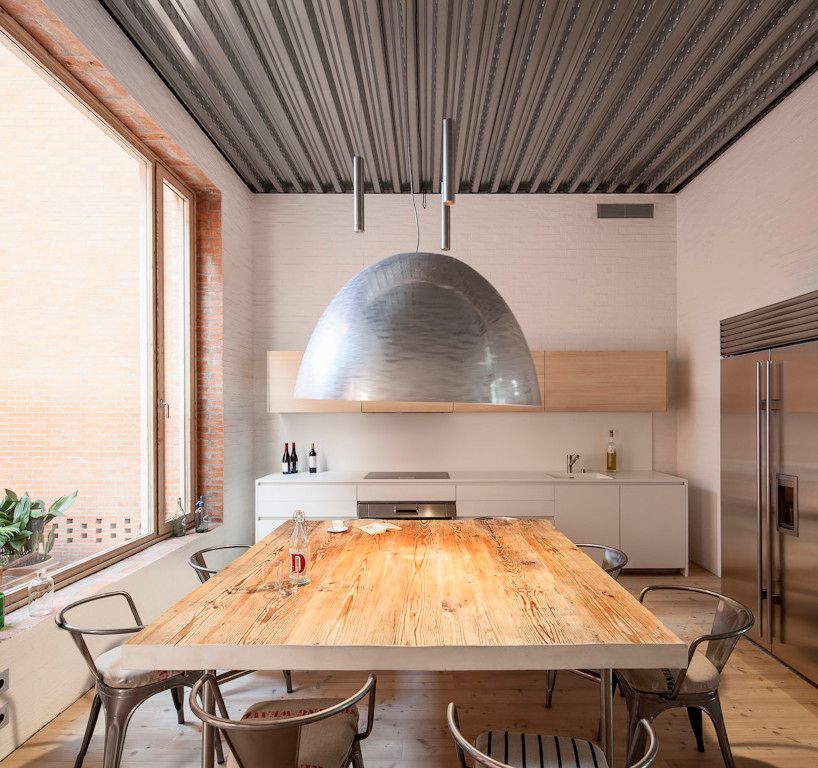 House 1014 by H Arquitectes — The kitchen interior reveals a narrow, elongated space maximized through vertical organization.
