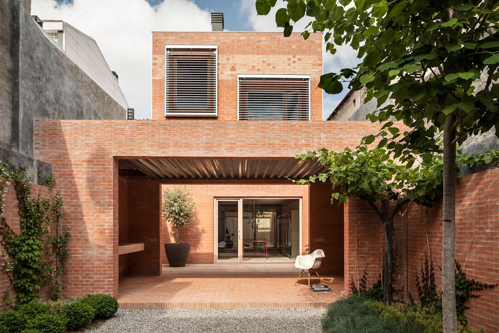 House 1014 by H Arquitectes — The courtyard facade of House 1014 presents a studied composition of material restraint within dense urban constraints.