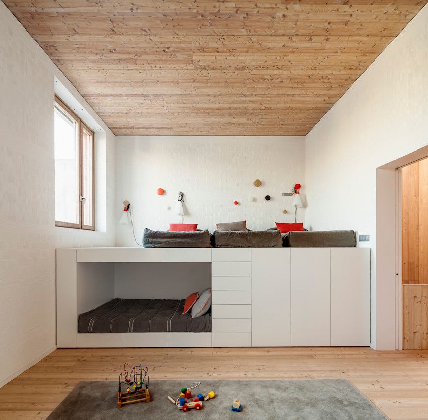 House 1014 by H Arquitectes — A children's bedroom demonstrates spatial efficiency through integrated storage and sleeping platforms.
