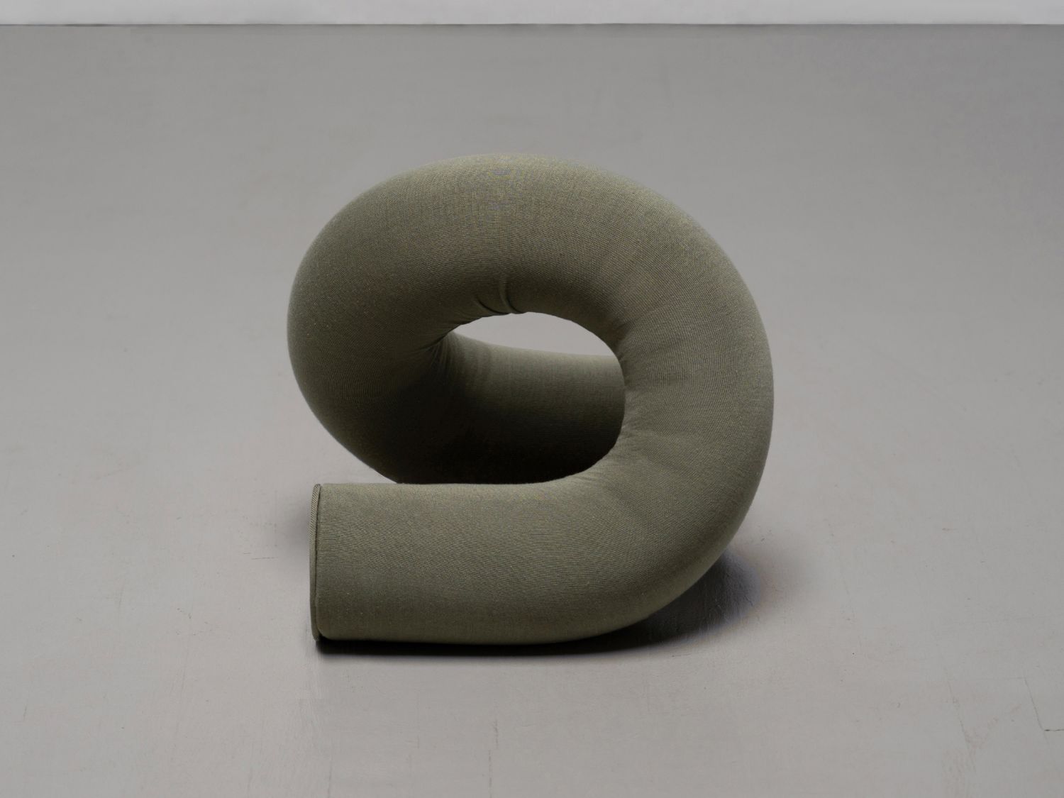 ULU Collection by Ara Thorose — A sculptural foam form wrapped in sage-green textile, configured in a serpentine curve with a central void.