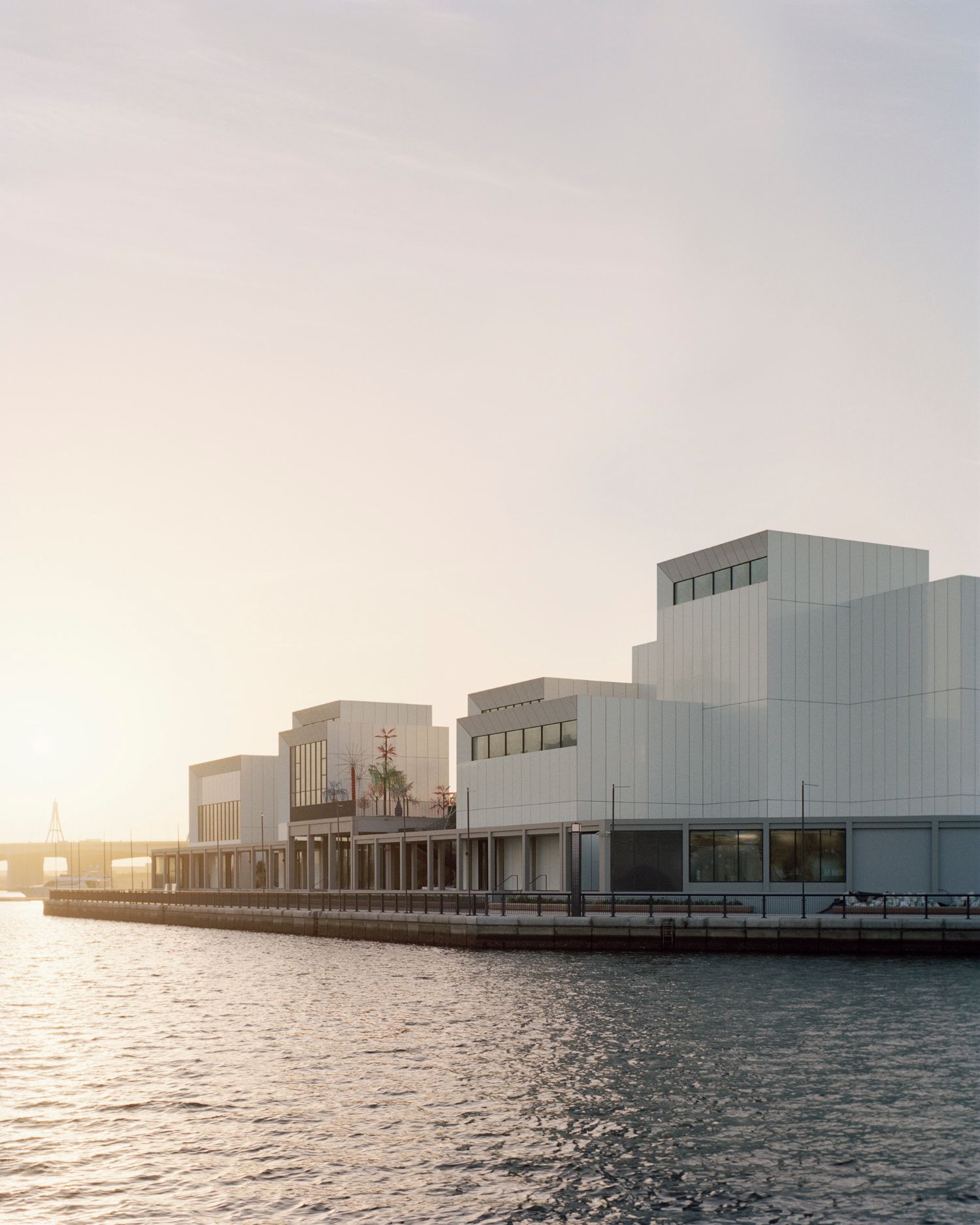 Jameel Arts Centre Dubai by Serie Architects — The Jameel Arts Centre's waterfront facade is composed of staggered white aluminum panels with vertical ribbing, interrupted by inset grey concrete sections...