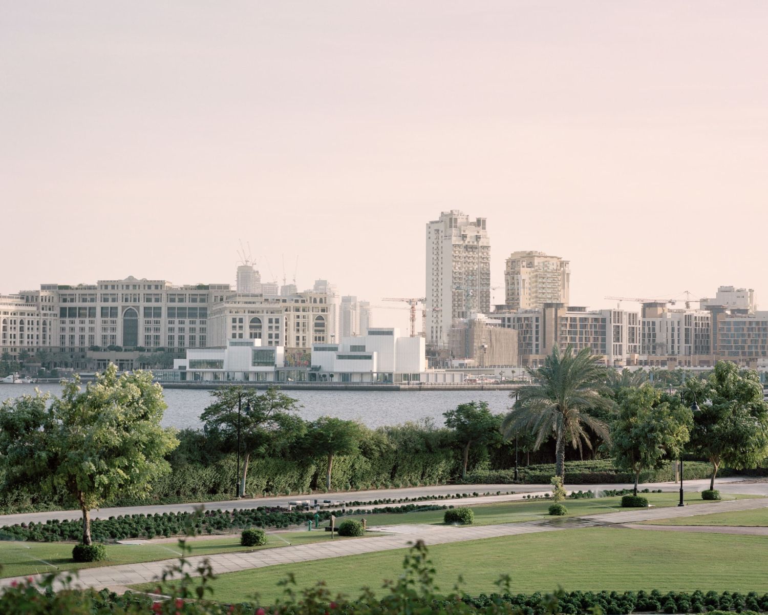 Jameel Arts Centre Dubai by Serie Architects — The Jameel Arts Centre's waterfront facade presents a composed rhythm of vertical ribbed aluminum cladding punctuated by inset grey concrete panels.
