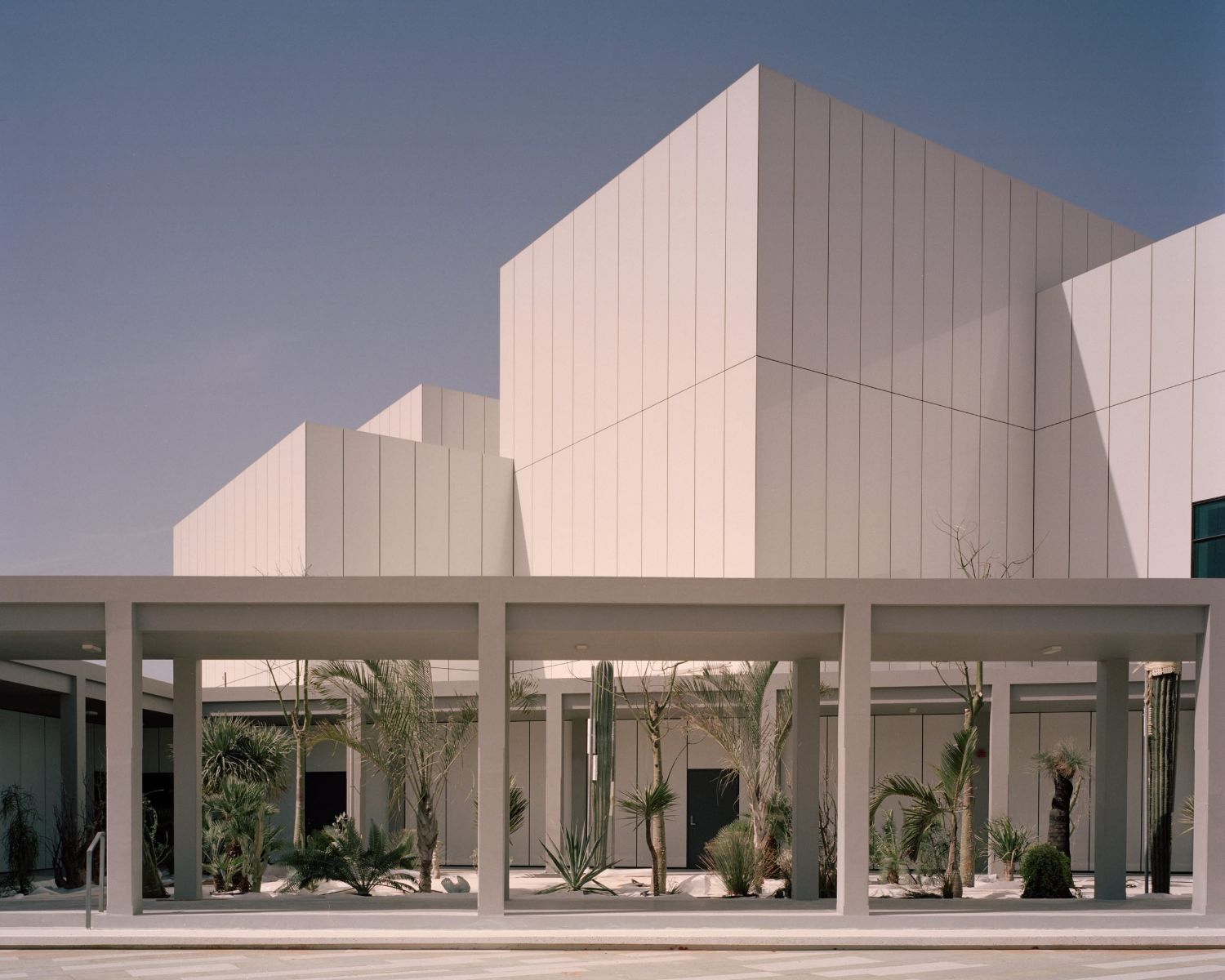 Jameel Arts Centre Dubai by Serie Architects — The Jameel Arts Centre's street facade presents a tripartite composition anchored by a post-and-beam colonnade of grey concrete columns supporting a deep...