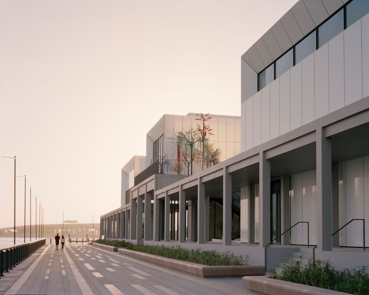 Jameel Arts Centre Dubai by Serie Architects — The Jameel Arts Centre's waterfront facade reveals a methodical composition of corrugated white aluminum cladding with pronounced vertical ribbing,...
