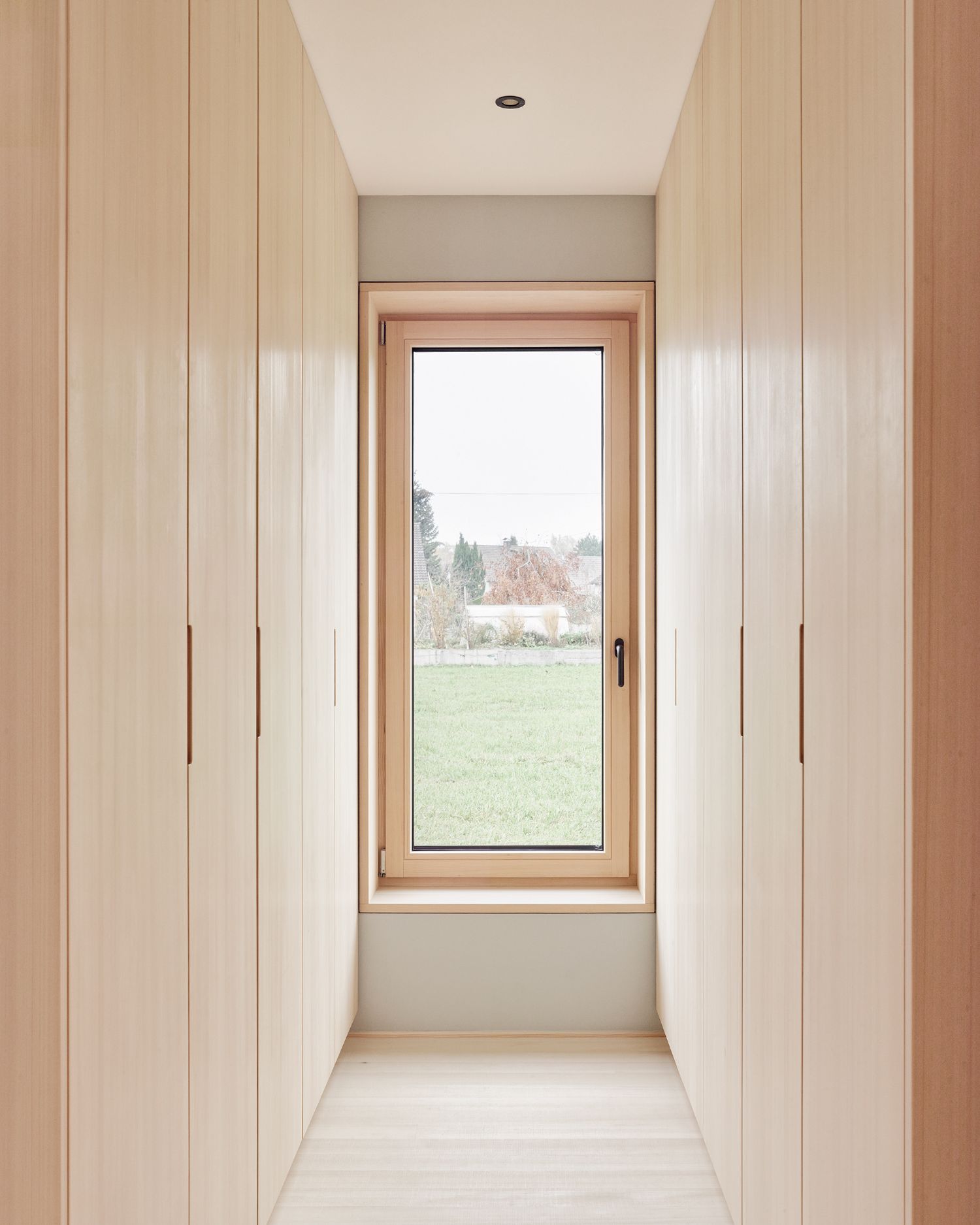 House ZF by Bernd Riegger — A timber-lined passage frames the view to landscape beyond.