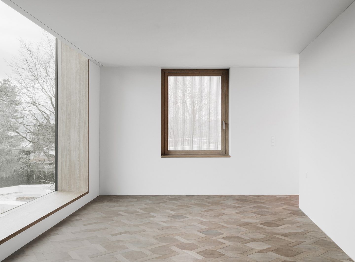 House for an Art Collector by Think Architecture — A minimalist interior space demonstrates material hierarchy through flooring transitions.