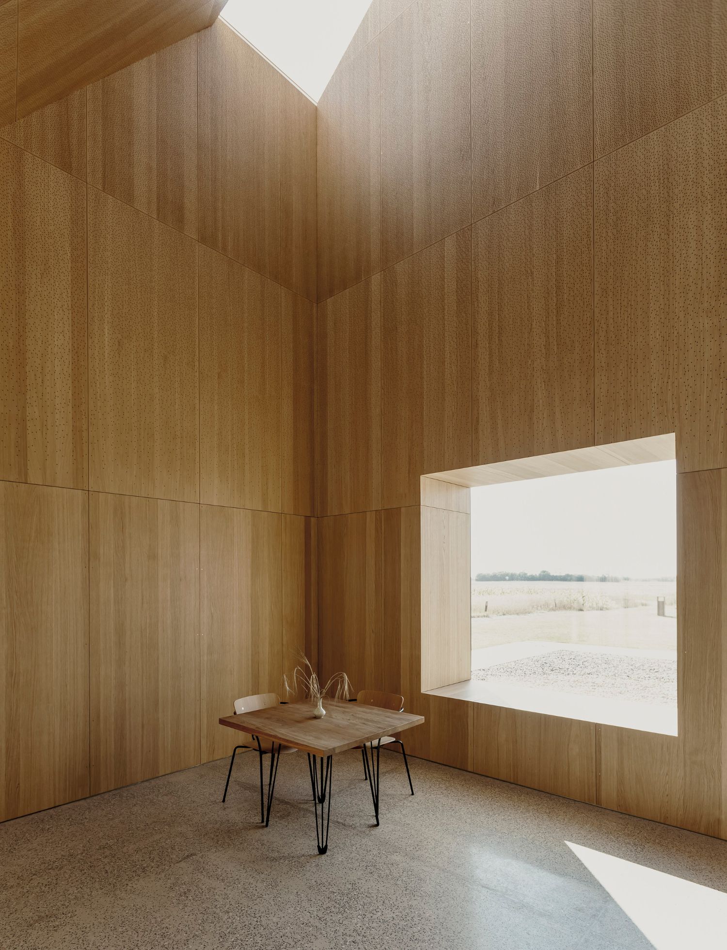 House of Grain by Reiulf Ramstad Arkitekter — Interior view of timber-clad space with vertical wood paneling in warm honey tones.