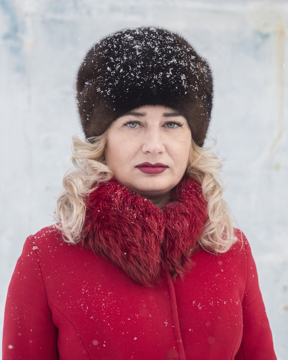 Удачный / Lucky by Hanne Van Assche — A portrait photograph of a woman positioned against a blurred winter landscape background.