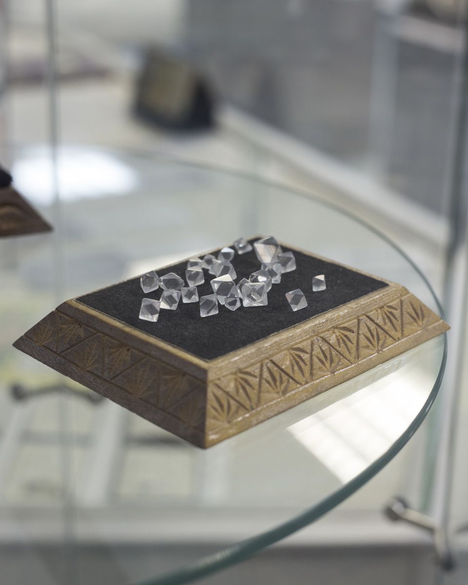 Удачный / Lucky by Hanne Van Assche — A display case presents raw diamond specimens arranged on black velvet within a wooden presentation box.