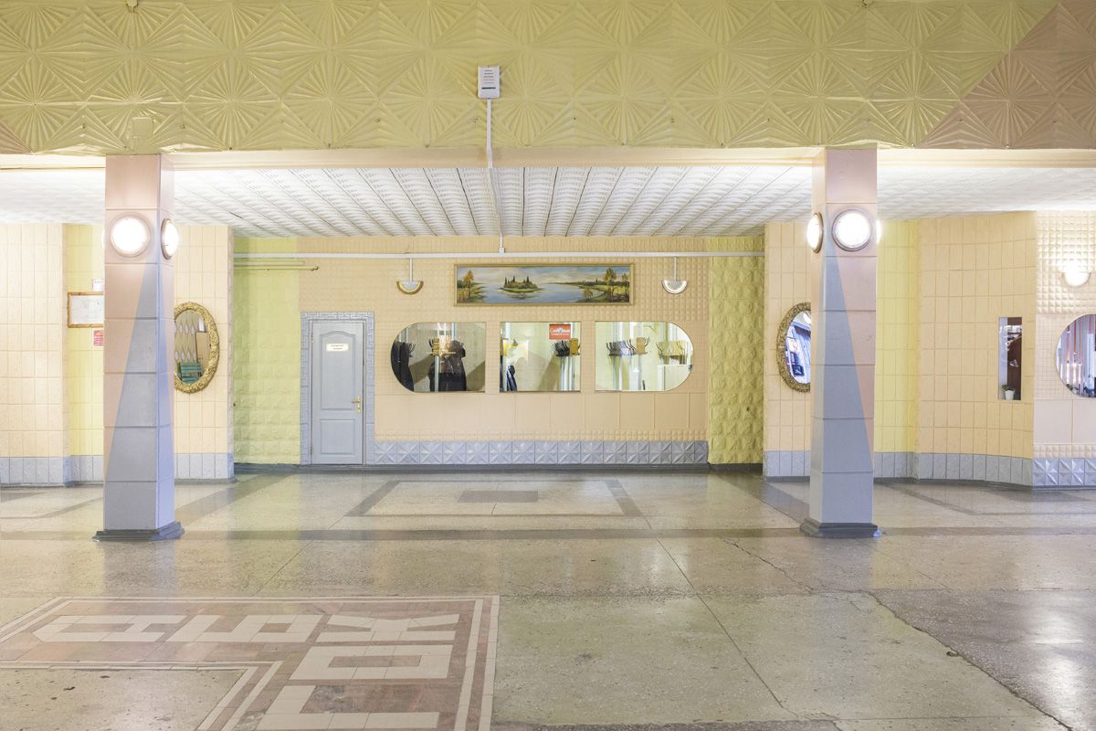 Удачный / Lucky by Hanne Van Assche — A Soviet-era public interior, likely a bathhouse or communal facility in Udachny, captured in symmetrical frontality.