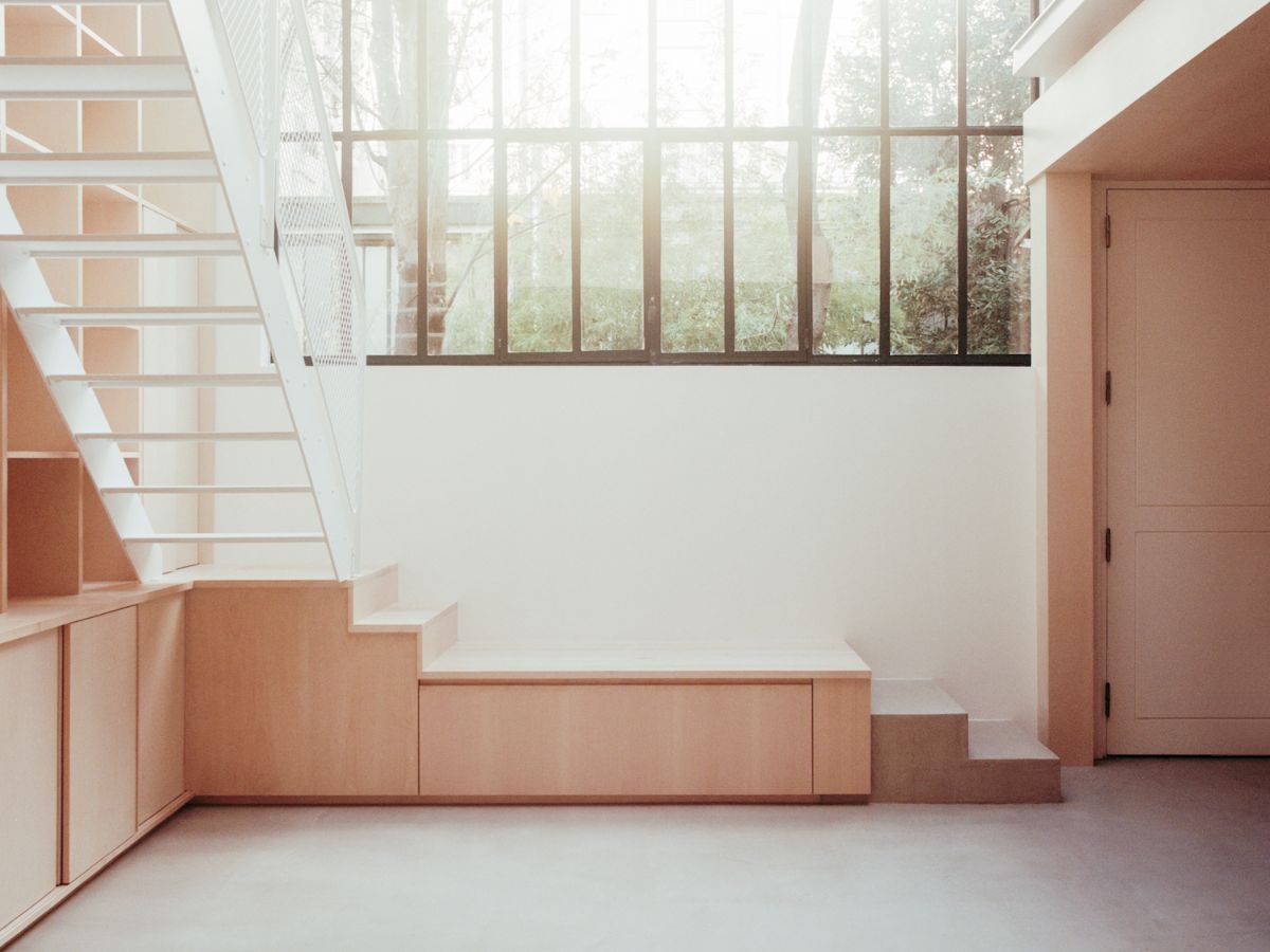 Jean Moulin Atelier – House by Atelier NEA — A double-height studio interior organized around custom oak cabinetry and built-in storage.