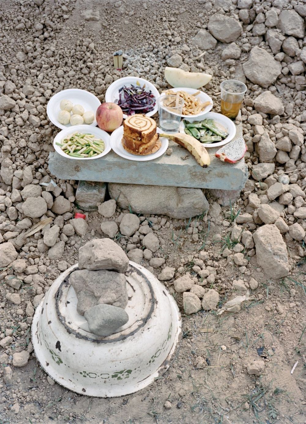 Watering My Horse by Xiaoxiao Xu — A makeshift meal staged on a concrete platform at the Great Wall's ruins, photographed from directly above.