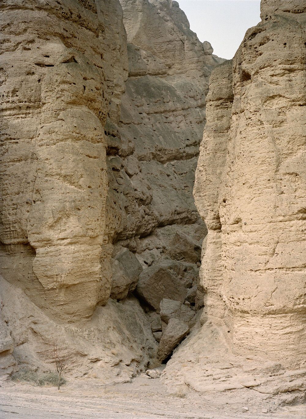 Watering My Horse by Xiaoxiao Xu — A narrow passage cuts through Ming dynasty stone masonry, with rectangular blocks stacked in regular courses on both flanking walls.