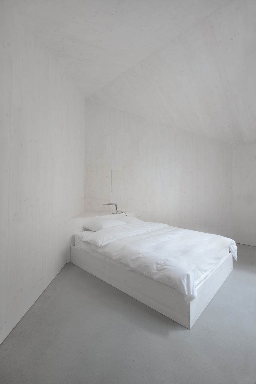En Chalméry House by Christian Dupraz Architects — A minimalist bedroom within En Chalméry House demonstrates the project's commitment to spatial restraint.