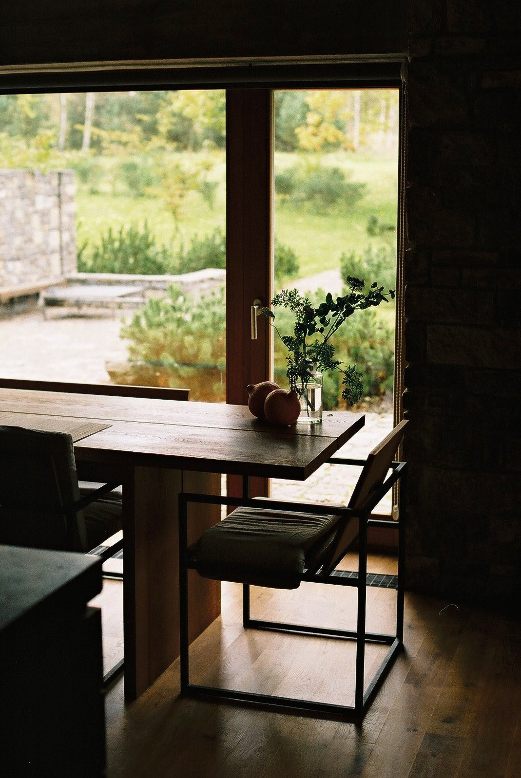 Wygnanowice House Over Crystal Clear Springs captured by Thisispaper Studio — Interior view from a dining space toward expansive glazed doors and landscape beyond.