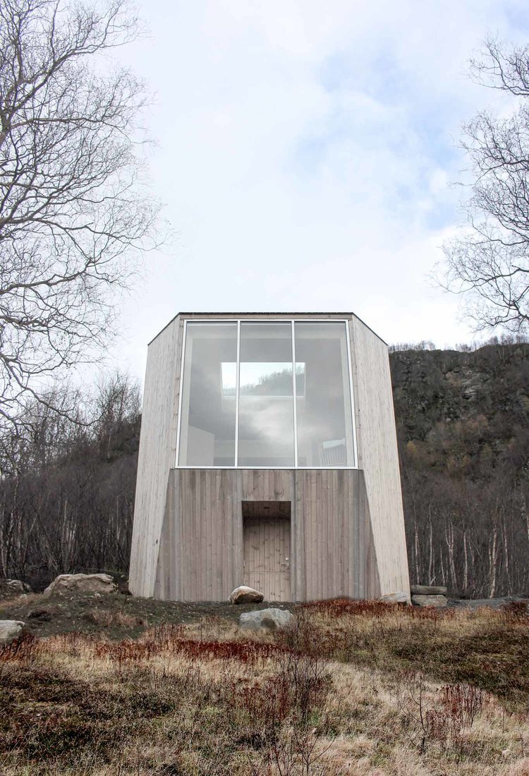 Røldal Cabin by Reiulf Ramstad Arkitekter — The Røldal Cabin presents a geometric trapezoidal volume composed of two distinct material zones.