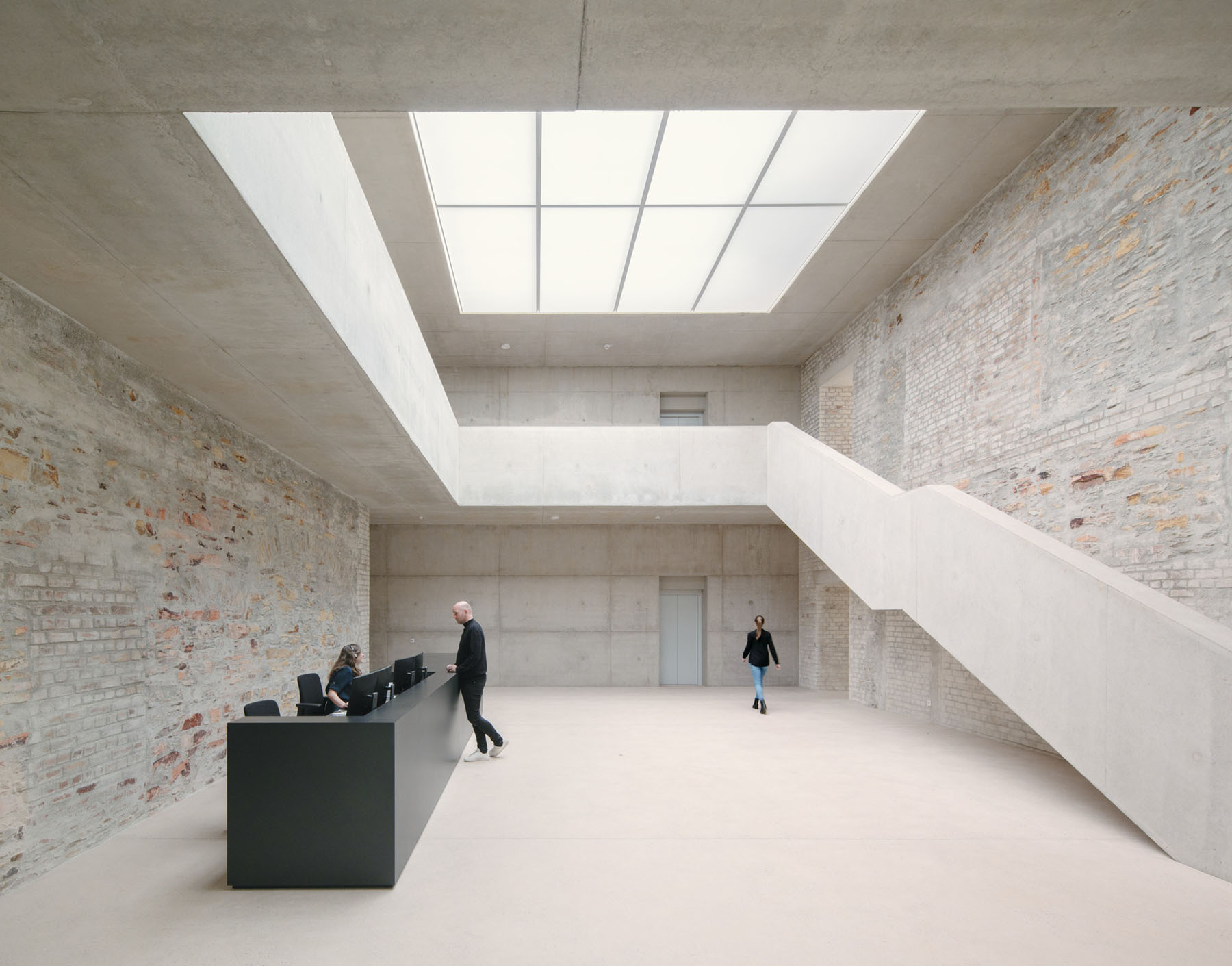 Jacoby Studios Headquarters by David Chipperfield Architects — The atrium of Jacoby Studios Headquarters reveals the conversion strategy through material contrast: weathered brick walls with rust-colored mortar retain...