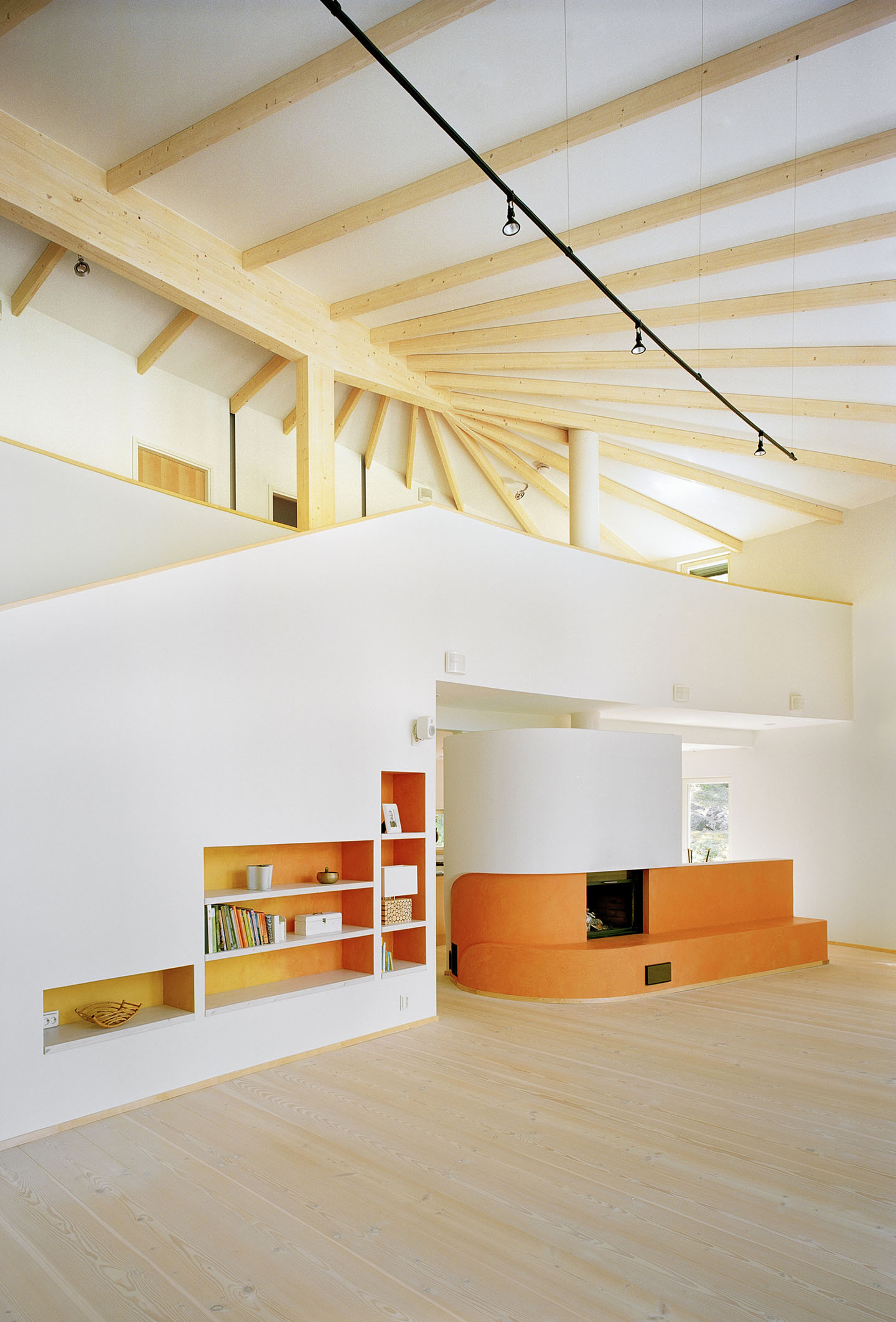 Villa Musu by Sanaksenaho Architects — Interior view of Villa Musu's double-height living space revealing the timber structural system overhead.