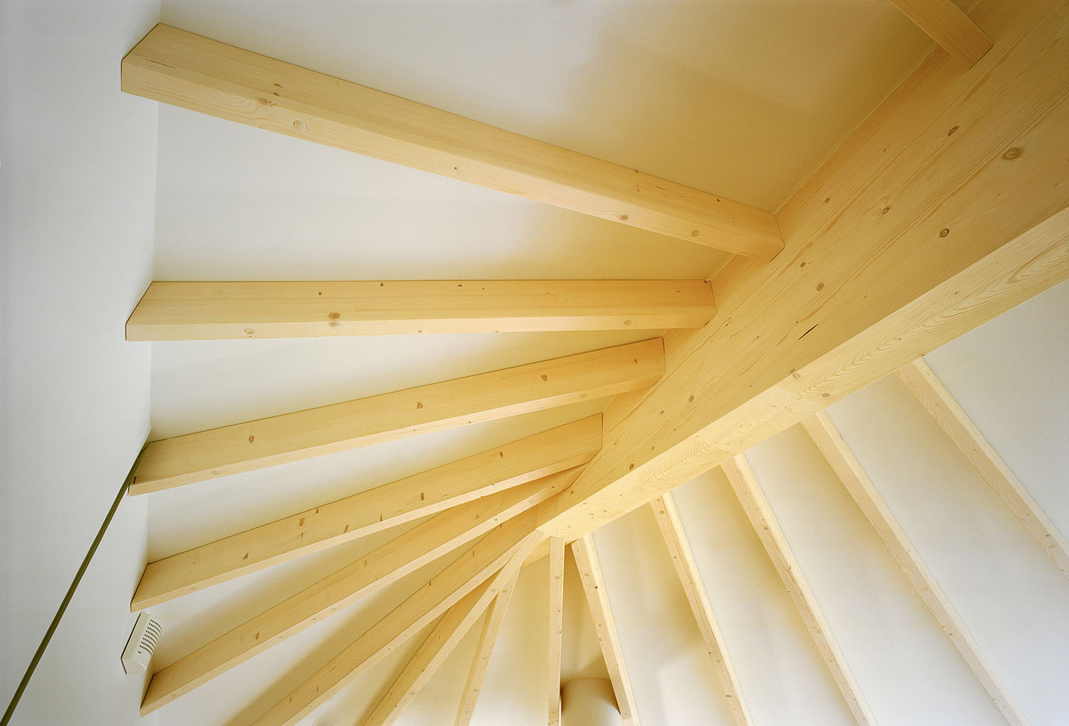 Villa Musu by Sanaksenaho Architects — Overhead view of a timber staircase spiraling downward, revealing the structural logic of Villa Musu's wooden construction.
