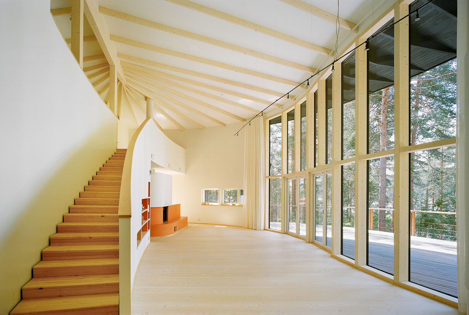 Villa Musu by Sanaksenaho Architects — The double-height interior showcases the project's timber-frame construction with exposed wooden roof ribs creating a branching pattern overhead.