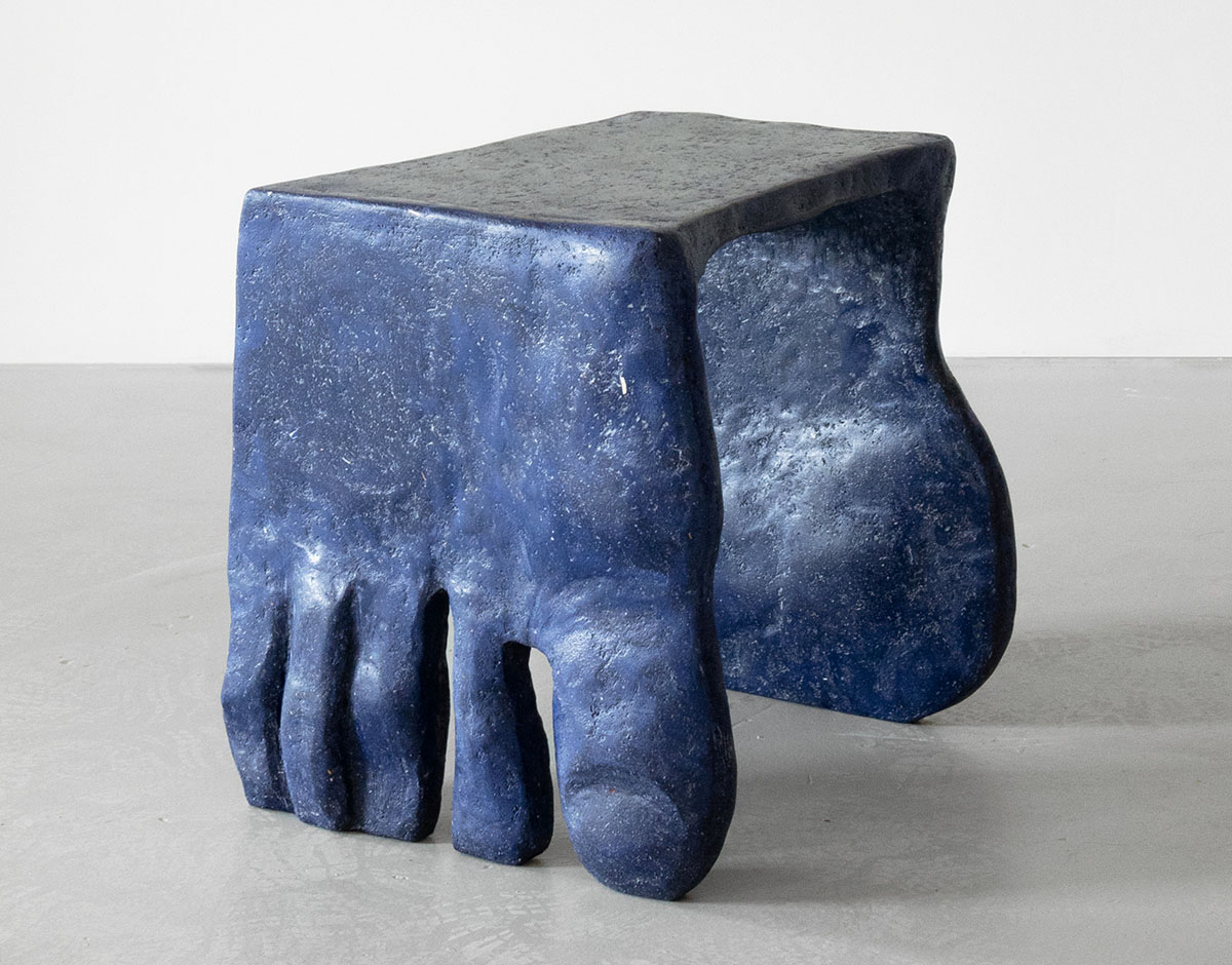 Roommates by Barbora Žilinskaite — A sculptural stool from Barbora Žilinskaite's Roommates series presents a composite form cast in slate-blue pigmented material with visible grey patina on...